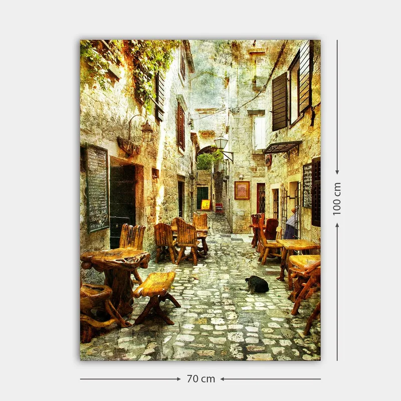 Canvastavla 70x100 cm - Pittoresk gränd med träbord och stolar, omgiven av gamla stenhus - Brun / Grå / Grön - Products - Inredning - Tavlor & posters - Canvastavla