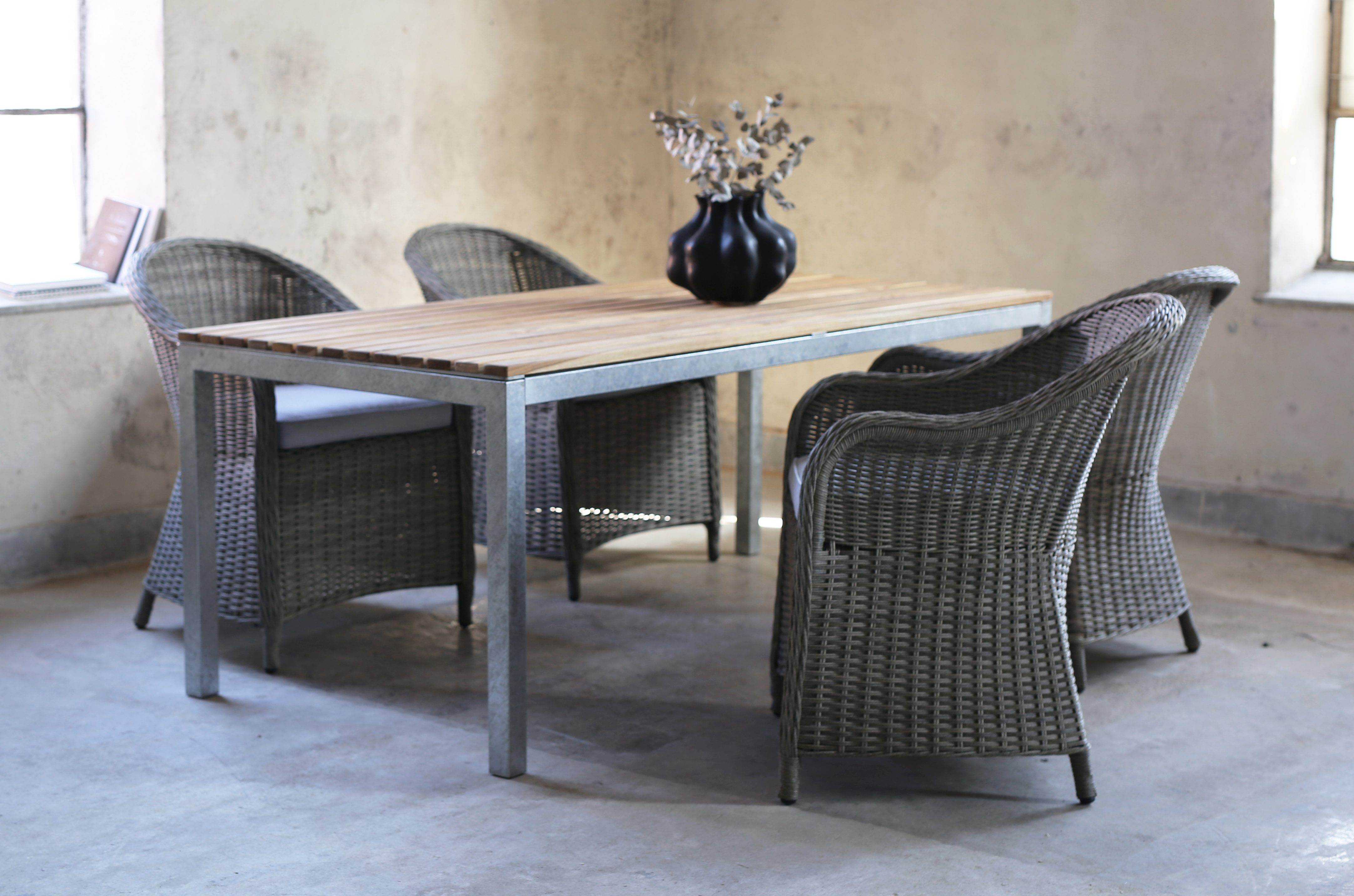 Ruokailuryhmä Alva: Ruokapöytä tiikkiä / galvanoitua terästä ja 4 Mercury-nojatuolia harmaata synteettistä rottinkia Ruokailuryhmä Alva: Ruokapöytä tiikkiä / galvanoitua terästä ja 4 Mercury-nojatuolia harmaata synteettistä rottinkia